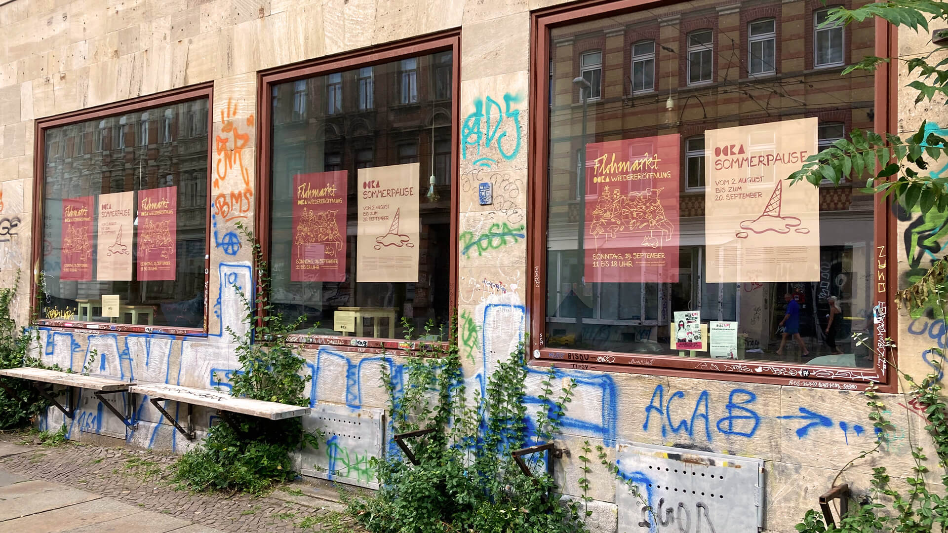 Außenansicht des Cafes mit Postern in den Fenstern